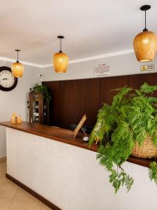 a kitchen with a counter with a clock and plants at Hotel Casarão Pitangueiras in Guarujá