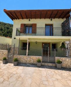 a house with a porch and a balcony at Daisy House Golden Beach Area in Potamiá
