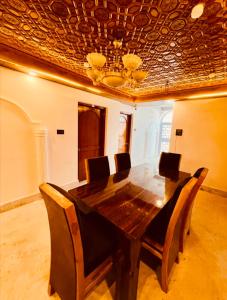 a dining room table with chairs and a ceiling at Rahat Resort in Srinagar