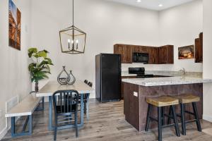 a kitchen with a black refrigerator and a table with stools at Moab Redcliff Condos in Moab
