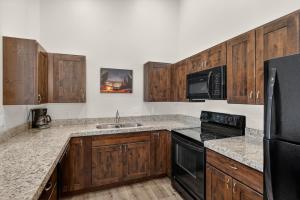 a kitchen with wooden cabinets and black appliances at Moab Redcliff Condos in Moab