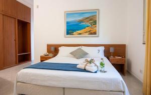 a bedroom with a large bed with a blue blanket at Appartamenti in Villa Polimnia in Fontane Bianche