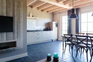 cocina con mesa y sillas y comedor en Wertemerhoeve Vakantiewoningen en Evertsoord