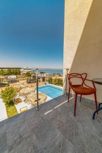 a red chair sitting on a balcony with a view of a pool at InWaves in Vama Veche