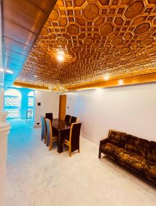 a dining room with a table and a couch at Rahat Resort in Srinagar