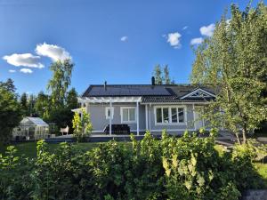 a white house with a roof at Villa Herttala in Jyväskylä