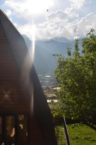 a view from the side of a house with the sun shining at MM's Cottage in Kazbegi