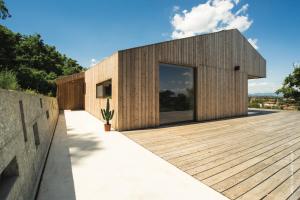 a timber clad house with a wooden deck at B&B La Mugletta in Feriole