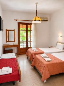 a bedroom with two beds and a window at Gian Petro Apartments in Sidari