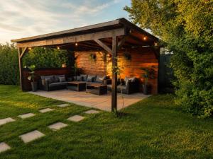a wooden pavilion with couches and tables in a yard at VaMood in Vama Veche