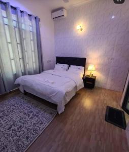 a bedroom with a large white bed and a window at Vancovuer homes in Dodoma