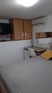 a bedroom with a bed and a desk and a table at Studio apartman Kornelija in Lumbarda