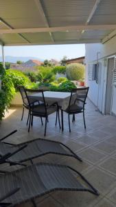 a table and chairs sitting on a patio at Studio apartman Kornelija in Lumbarda