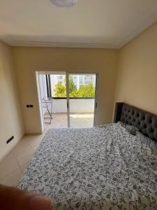 a bedroom with a large bed and a sliding glass door at Marina golf A in Asilah