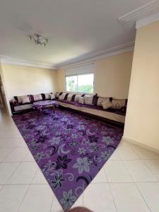 a living room with a couch and a purple rug at Marina golf A in Asilah +1 photo