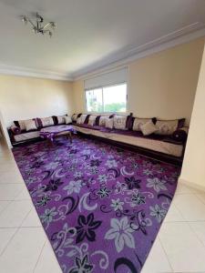 a living room with a couch and a purple rug at Marina golf A in Asilah