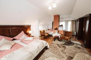 a bedroom with two beds and a table and chairs at Vila Hubertus in Avrig +93 photos