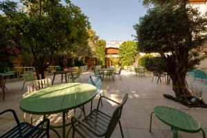 an outdoor patio with tables and chairs and trees at Christmas Hotel - Jerusalem in Jerusalem