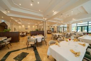 a restaurant with white tables and chairs and windows at Christmas Hotel - Jerusalem in Jerusalem