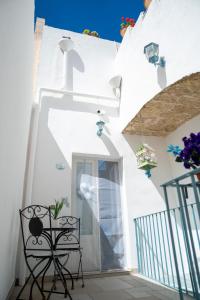 a white house with a table and a chair at Ercole B&B in Ugento