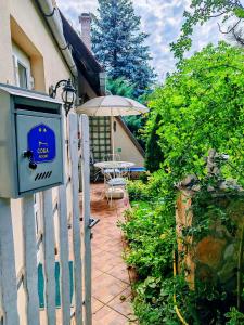 a house with a fence with a table and an umbrella at Inner Harmony Garden in Kanjiža +7 photos