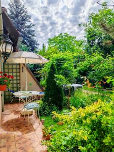 a patio with an umbrella and a table and chairs at Inner Harmony Garden in Kanjiža