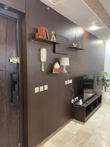 a room with a dark brown wall with shelves and a lamp at Appartement cozy in Oujda