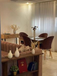 a living room with a couch and a table and chairs at Appartement cozy in Oujda