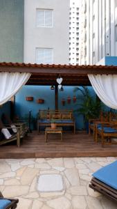 a wooden patio with benches and a blue wall at Hotel Casarão Pitangueiras in Guarujá