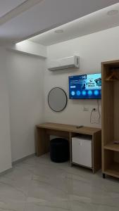 a room with a desk and a tv on a wall at Laska's Rooms Sarandë in Sarandë