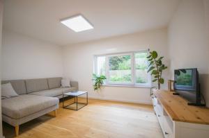 a living room with a couch and a tv at Loft Heidelberg West in Heidelberg