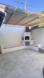 a patio with a pizza oven under a roof at Melisa Garden in Cunda