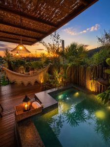 a swimming pool in a backyard with a hammock at Loft Mandalua in Serra do Cipo