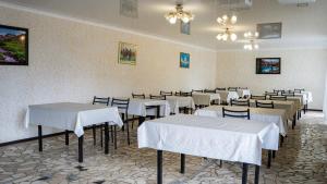 a dining room with white tables and chairs at Бархат плюс in Tossor