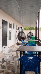 a table and chairs on a porch with a table and chairs at Бархат плюс in Tossor