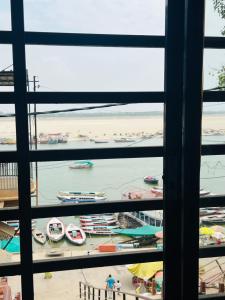 a view of a beach from a window with boats in the water at Alaknanda lodge in Varanasi