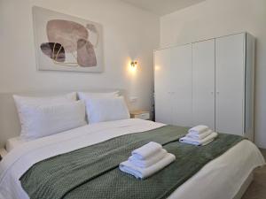 a bedroom with a bed with two towels on it at Villa 1902 Omišalj in Omišalj