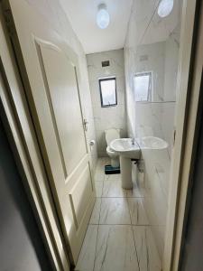 ein weißes Badezimmer mit Waschbecken und Toilette in der Unterkunft SimPhil Haven in Bulawayo + 4 Fotos
