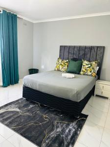ein Schlafzimmer mit einem großen Bett in einem Zimmer in der Unterkunft SimPhil Haven in Bulawayo