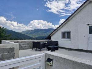 a patio with a table and chairs on a balcony at Duvnjak Rooms & House in Livno