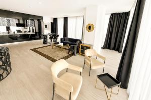 a living room with two chairs and a table at Maritimo ApartHotel in Constanţa