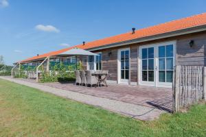 een huis met een patio met een tafel en stoelen bij Wertemerhoeve Vakantiewoningen in Evertsoord