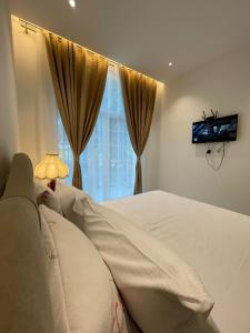 a bedroom with a bed and a tv on a wall at Igli Hotel in Lezhë