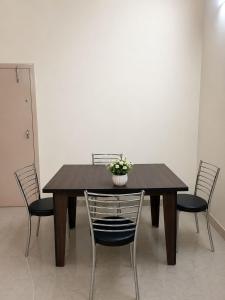 a wooden table with chairs and a vase with flowers on it at Moonleaf Stay, Guwahati in Guwahati