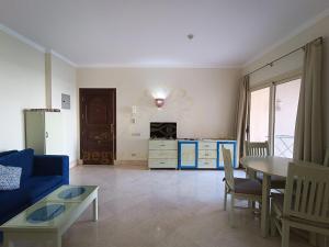 a living room with a blue couch and a table at OrientalCoast Marsa Alam Private Beach in Quseir