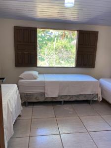 a bedroom with two beds and a window at Pousada Orienttal in Santarém