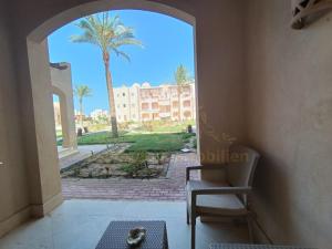 an open door to a building with a palm tree at OrientalCoast Marsa Alam Private Beach in Quseir +5 photos