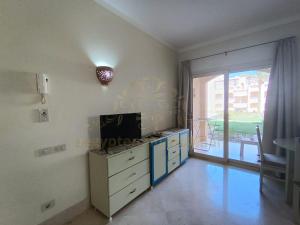 a room with a desk with a television and a window at OrientalCoast Marsa Alam Private Beach in Quseir
