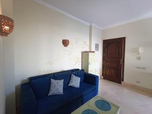 a blue couch in a living room with a door at OrientalCoast Marsa Alam Private Beach in Quseir