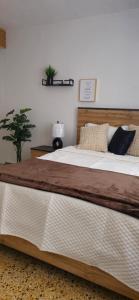a large bed with a wooden headboard in a bedroom at D'Ponke Guest House in Cayey
